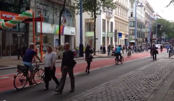 Mehrere Fußgänger und Radfahrer auf der Fahrbahn der provisorisch beruhigten Mariahilfer Straße.